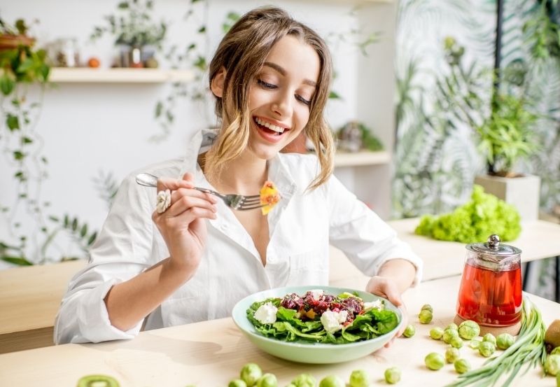 come disintossicarsi dopo le feste: l'alimentazione sana con una foto di una ragazza che mangia un'insalata